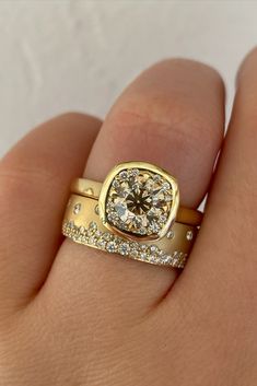 a woman's hand holding a gold ring with diamonds on it