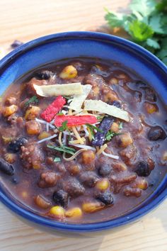 a blue bowl filled with chili and beans