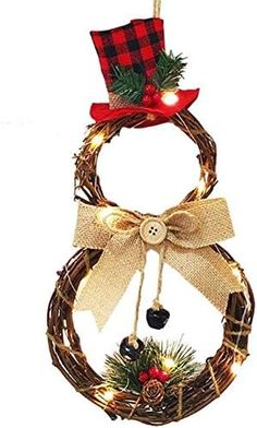 a christmas wreath with lights hanging from it's side and a bow on top