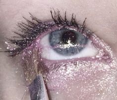 an extreme close up shot of someone's eye with glitter on it