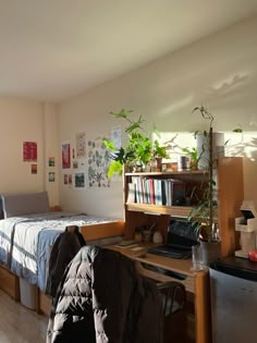 a bedroom with a bed, desk and bookshelf next to a laptop computer