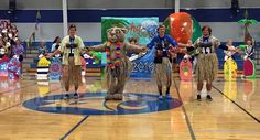 some people in costume are standing on a court and one person is holding a balloon