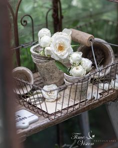 some white flowers are sitting in a wire basket