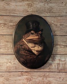 a frog wearing a top hat and bow tie in a glass plate on a wooden wall