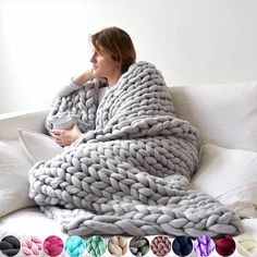 a woman sitting on a couch wrapped in a blanket