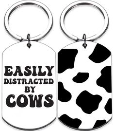 two dog tags with the words easily distracted by cows in black and white on them