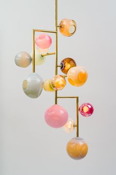 an assortment of colorful glass balls hanging from a gold pole