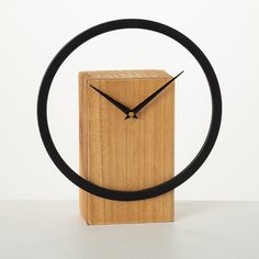 a clock made out of wood with a black band around it's face and hands