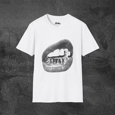 A y2k grillz tee with big lips design, this unisex T-shirt is made from 100% ring-spun cotton, offering a lightweight feel perfect for year-round wear. The classic fit and crew neckline provide a versatile style suitable for any occasion. This tee comes in 2 color ways and is perfect's for y2k/streetwear style. For any suggestions, questions, comments, or concerns always feel free to contact me anytime. Product features - Knit in one piece without side seams for reduced fabric waste - Ribbed knit collar for elasticity and shape retention - Twill tape shoulder tape for stability and prevent stretching - Made from durable and smooth fabric perfect for printing - Certified by Oeko-Tex for safety and quality assurance Care instructions - Do not dryclean - Machine wash: warm (max 40C or 105F) - Gap T-shirt With Letter Print For Streetwear, Gray Letter Print T-shirt For Streetwear, Fitted White T-shirt With Graffiti Print, Affordable Fitted Graffiti Print T-shirt, Unisex White T-shirt With Graffiti Print, Style Streetwear, Lip Designs, Y2k Streetwear, Twill Tape