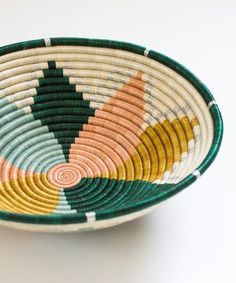 a colorful bowl is sitting on a white surface