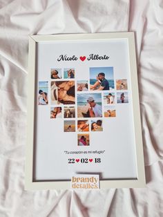 a white frame with pictures of people in the shape of a heart on top of a bed