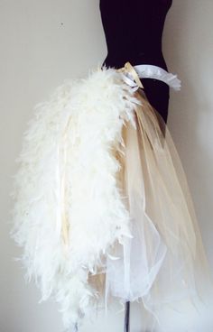 a mannequin wearing a dress made out of white feathers and tulle skirt