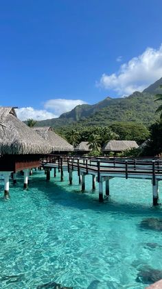 the water is crystal blue and clear with some huts on it's roof overhangs