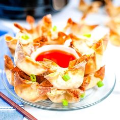 an appetizer dish on a glass plate with chopsticks and sauce in the background