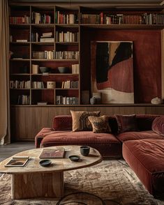 a living room filled with furniture and bookshelves next to a painting on the wall