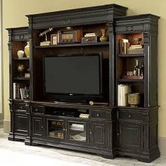 a large entertainment center with a flat screen tv on it's stand and shelves