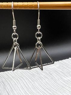 3D Triangle Dangle Stainless Steel Earrings. They lie flat, but when worn become 3D concentric triangles. Fun earrings for geometry teachers, math teachers or your neighborhood minimalist. All stainless steel. Silver Triangle Earrings, Minimalist Nickel-free Triangle Earrings, Silver Triangle Single Earring, Modern Triangle Metal Earrings, 3d Triangle, Nickel-free Metal Triangle Earrings, Steel Earrings, Stainless Steel Earrings, Fun Earrings