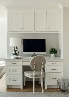 a white desk with a computer on it and a chair in front of the desk