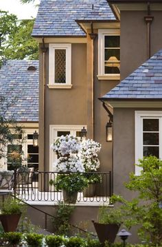 a house that has some flowers in the window boxes on the front and side of it