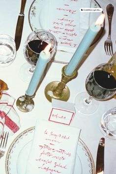 a table set with silverware, candles and menus for an elegant dinner party