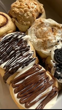 there are many different types of donuts on the plate together and one has chocolate icing