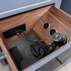 a hair dryer sitting inside of a wooden drawer