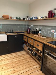 a kitchen with wooden floors and black cabinets