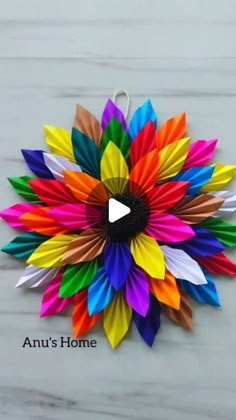 an origami flower made out of colored paper