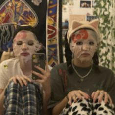 two people with cat ears on their faces are taking a selfie in front of a mirror