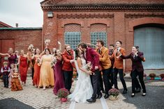 a group of people standing next to each other in front of a red brick building