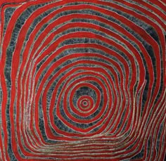 a red and blue rug with an abstract design in the shape of a spiral pattern