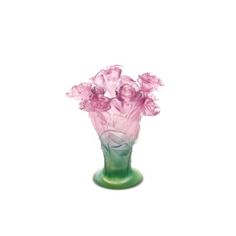 a green vase filled with pink flowers on top of a table