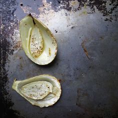 two pieces of artichoke sitting on top of a metal pan next to each other