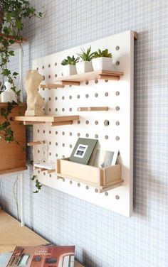 a shelf with some books and plants on it next to a wall mounted planter