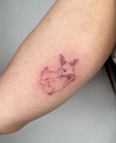 a woman's arm with a small tattoo of two rabbits on it, one is sitting down and the other is standing up