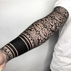 a man's arm with an intricate tattoo design on the arm and sleeve,