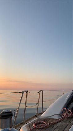 the deck of a boat at sunset with ropes on it