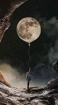 a woman holding onto a string attached to a large full moon in the night sky