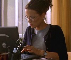 a woman sitting in front of a laptop computer