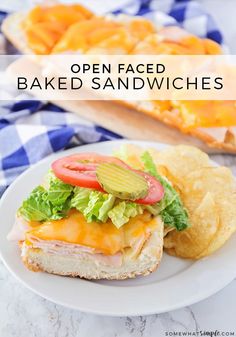 an open faced sandwich with lettuce, tomato and cheese on a white plate