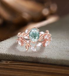 a ring with an aqua green stone surrounded by white and clear stones on top of a book