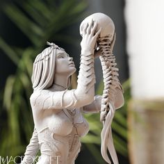 a statue of a woman holding a human skeleton in her right hand with both hands