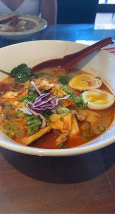 a white bowl filled with food on top of a wooden table