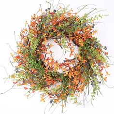 a wreath with orange and blue flowers is shown on a white background, surrounded by greenery