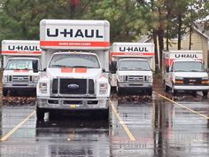 several trucks parked in a parking lot on a rainy day