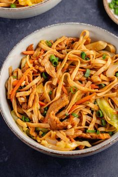 two bowls filled with stir fry noodles and vegetables