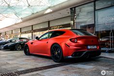 several different colored sports cars parked in front of a building