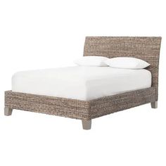 the bed is made with wicker and white linens on it's headboard