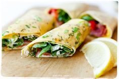 two burritos on a cutting board with lemon wedges