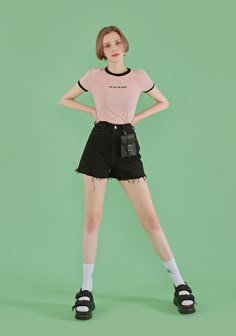 a woman in black shorts and a pink t - shirt is posing for the camera